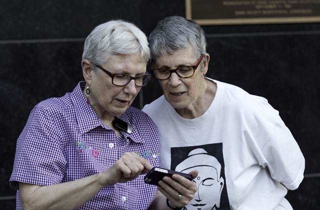 Older lesbian couple looking at smartphone